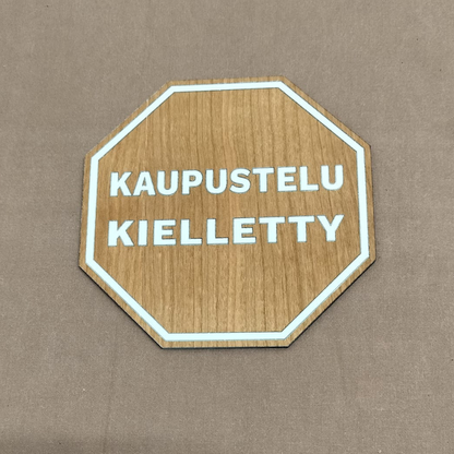 Kaupustelu kielletty -kyltti vanerista