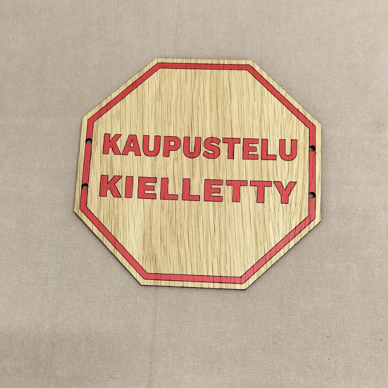 Kaupustelu kielletty -kyltti vanerista